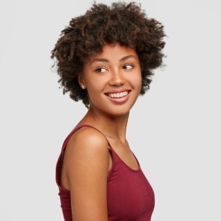 sideways-shot-pleased-relaxed-woman-with-healthy-dark-skin-looks-positively-aside